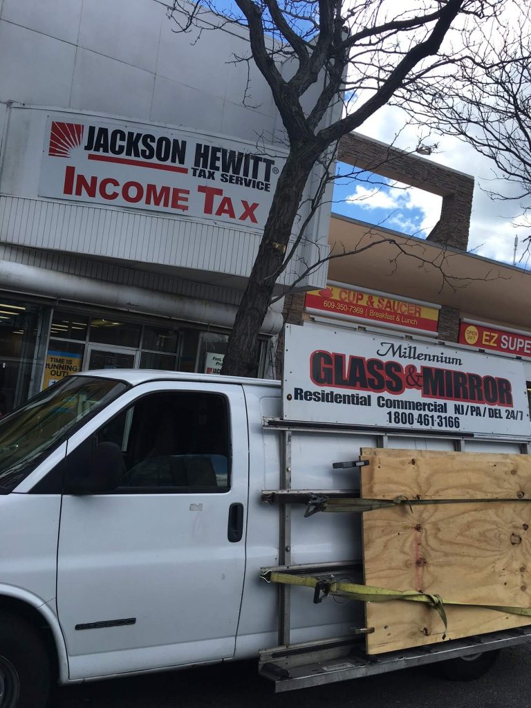 Millennium Glass Contractors van with a plywood board attached