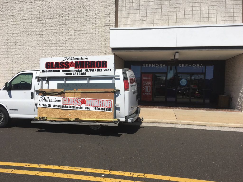 Millennium Glass Contractors van with a plywood board attached